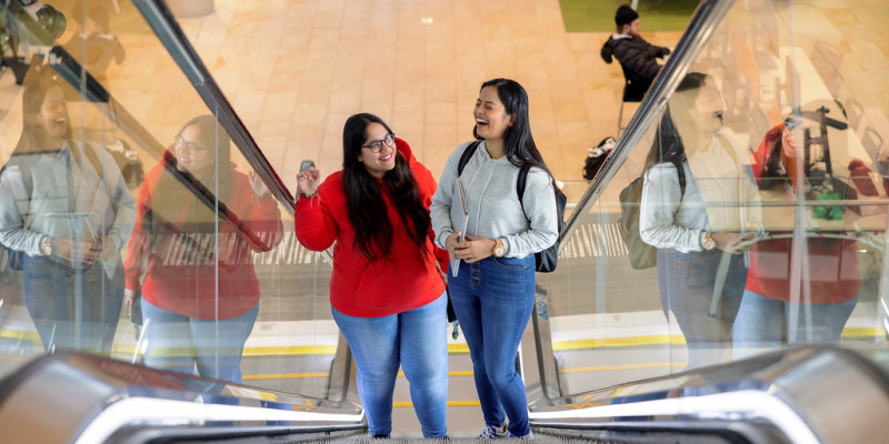 Students smiling on escalator